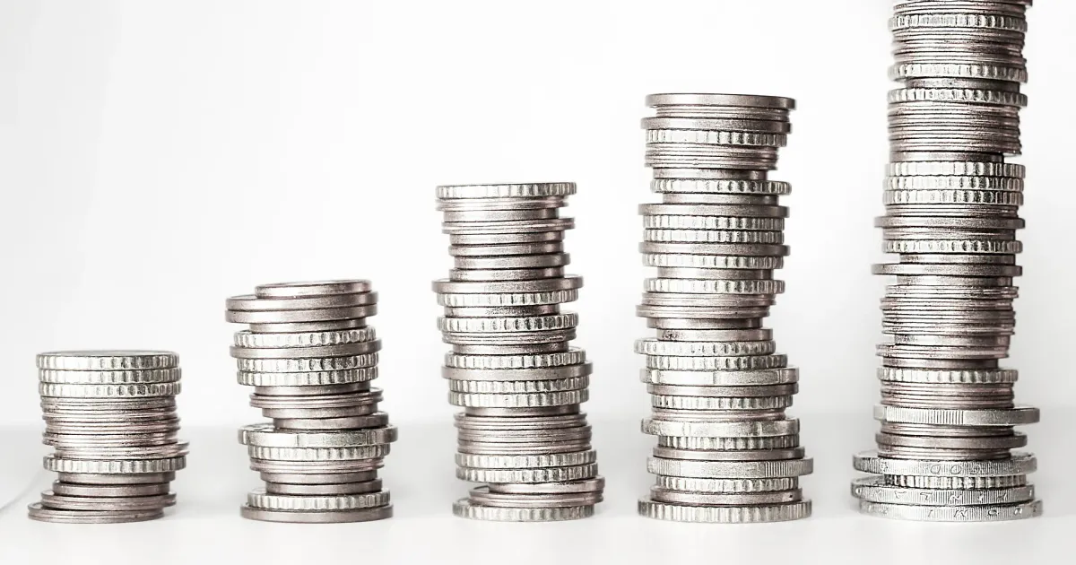 Five stacks of silver coins rising from short to tall