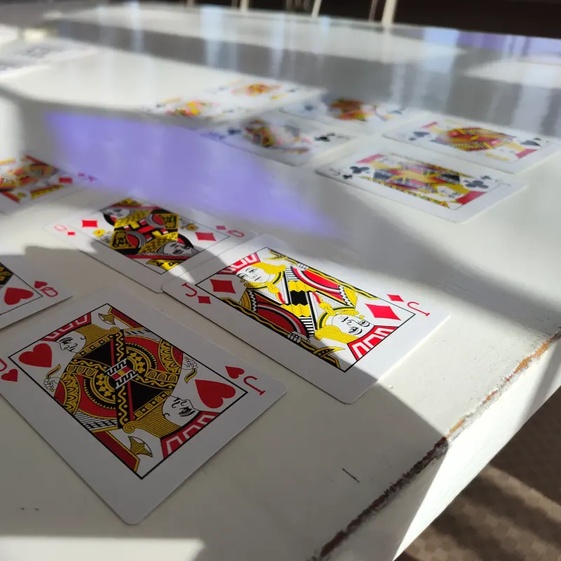 Jacks, queens and kings laid out on a white table in sunlight