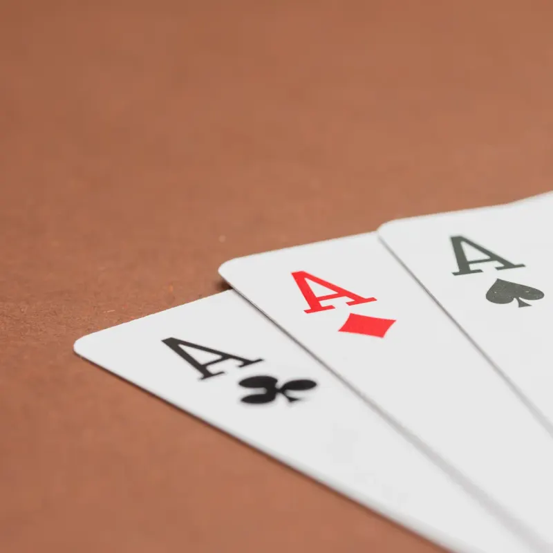 Four aces fanned out on a brown table